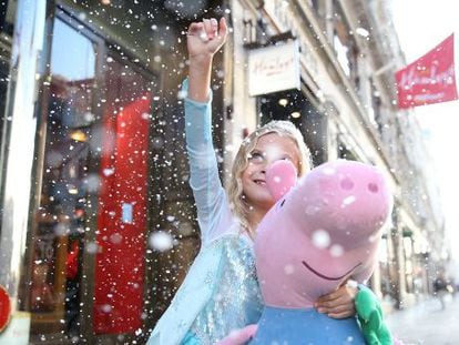Una ni&ntilde;a con un peluche de Pepa Pig frente a la tienda de juguetes Hamleys, en Londres.