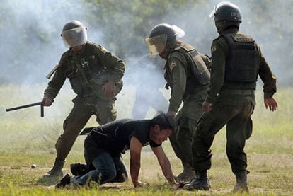 Tres policías antidisturbios bolivianos rodean a un manifestante indígena durante las protestas en el Parque Nacional Isidoro Sevuré (TIPNIS).