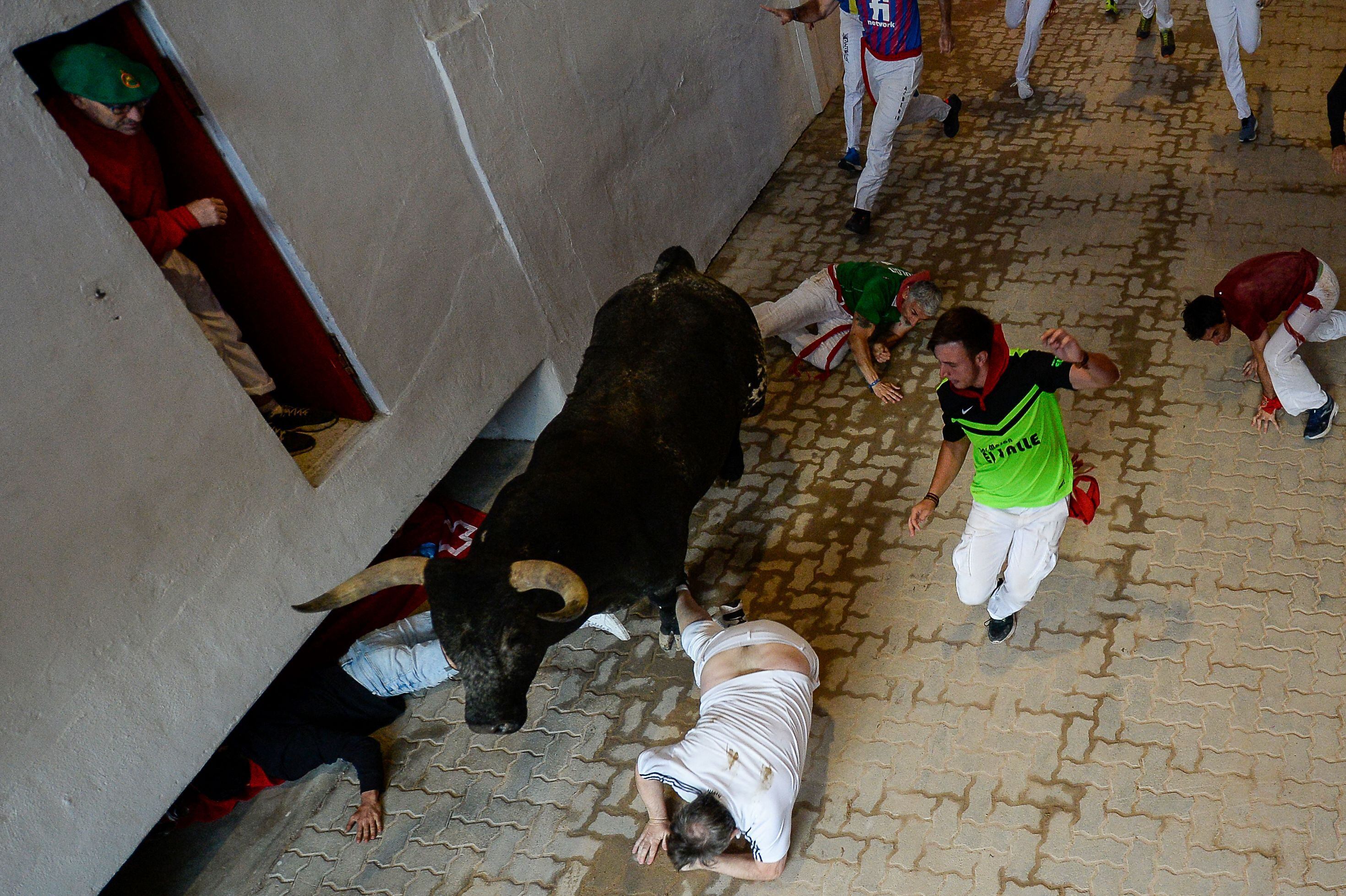 Varios corredores se tiran al suelo al paso de uno de los astados, por el callejón de la plaza de toros de Pamplona. 