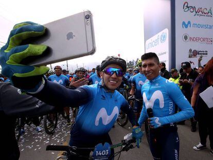 Nairo Quintana, a la derecha, junto a un aficionado en su marcha ciclista en Colombia.