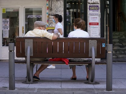 Una pareja de ancianos sentada en un banco.