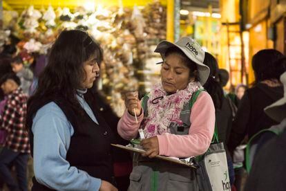 Una de las brigadistas de Ladies Hope le enseña a una mujer cómo realizarse la prueba para detectar el cáncer de cuello uterino, en  un mercado de Lima.