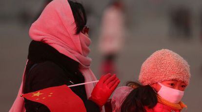 Una mujer y su hija, con mascarillas, cruzan la plaza de Tiananmen de Pekín el 30 de enero de este año.