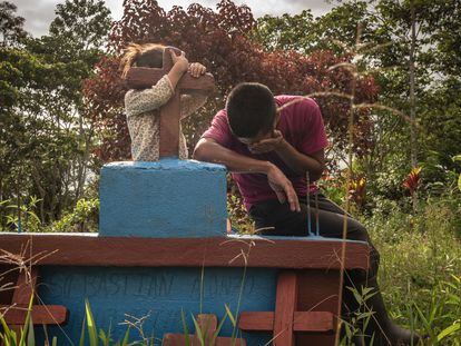 Juan Alonso, son of Sebastian, who was murdered at the age of 68 during a demonstration in opposition to the company, crying over his father's grave.