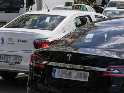 Veh&iacute;culos con licencias VTC junto a taxis por las calles de Madrid.