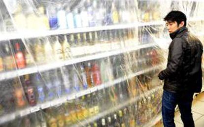 Un vendedor cubre los estantes con licores fuertes el pasado 14 de septiembre de 2012, en una tienda de Praga (R. Checa), después de que el Ministerio checo de Sanidad prohibiera, con efecto inmediato y por tiempo indefinido, la venta de licores con más del 20 % de alcohol.