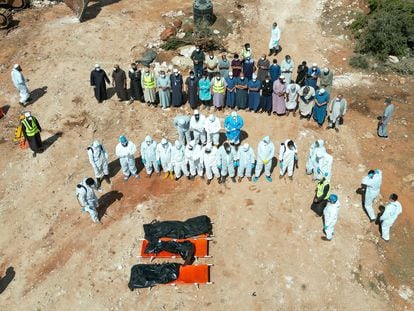 Un grupo de rescatistas voluntarios y familiares de varios fallecidos en las inundaciones preparan un funeral en el cementerio de Derna, el 19 de septiembre.
