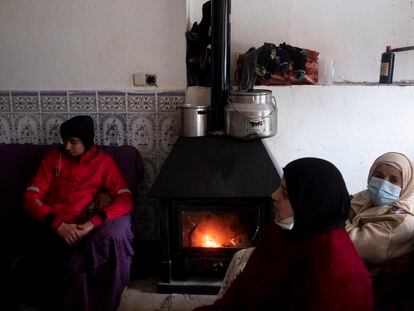 La familia Najah se calienta con una chimenea de madera en el interior de su casa de la Cañada Real.