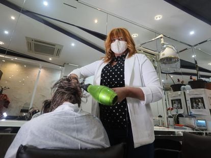 Monique Moreira de Lima atiende a una clienta en su peluquería en Madrid.