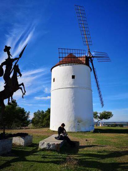 Un molino de viento junto a un perfil metálico de Don Quijote, a las afueras de Almodóvar del Campo.
