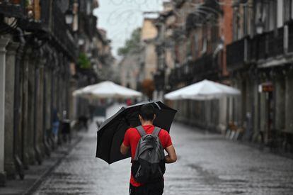 Un hombre se protege de la lluvia que cae este miércoles en Alcalá de Henares.