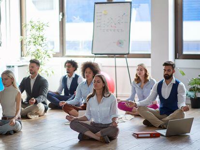 Grupo de empleados en una sesión de meditación en el trabajo.