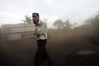 Un hombre se tapa la boca con un pa&ntilde;uelo para protegerse del polvo y la contaminaci&oacute;n atmosf&eacute;rica en India