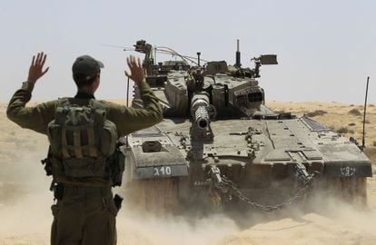 Un soldado israelí dirige las maniobras de un tanque junto a la frontera con Egipto.