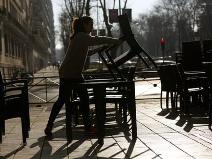 Una camarera monta una terraza en Madrid.