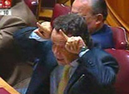 El ministro Manuel Pinho hace el signo de los cuernos en el Parlamento.