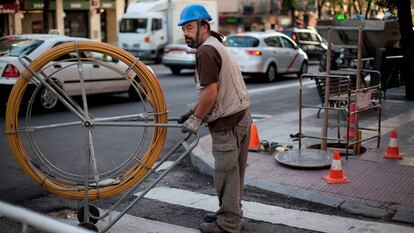 Imagen de un trabajador instalando cables de fibra óptica.