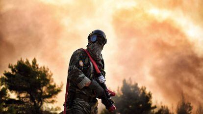 Un bombero trabaja en la extinción de un incendio cerca de Atenas (Grecia).