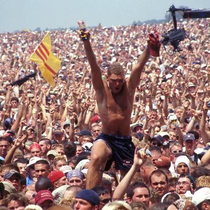 Un hombre se alza sobre la multitud que atestó el festival Woodstock, en Rome (Nueva York) en julio de 1999.