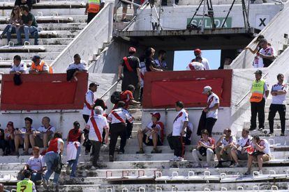 Aficionados de River Plate abandonan el estadio tras confirmarse la suspensión del partido ante Boca.