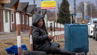 Una mujer africana huida del conflicto en Ucrania descansa en la frontera de Medyka, entre este país y Polonia, el 27 de febrero de 2022.