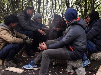 Un grupo de migrantes se calienta alrededor de un fuego, este viernes en Calais.