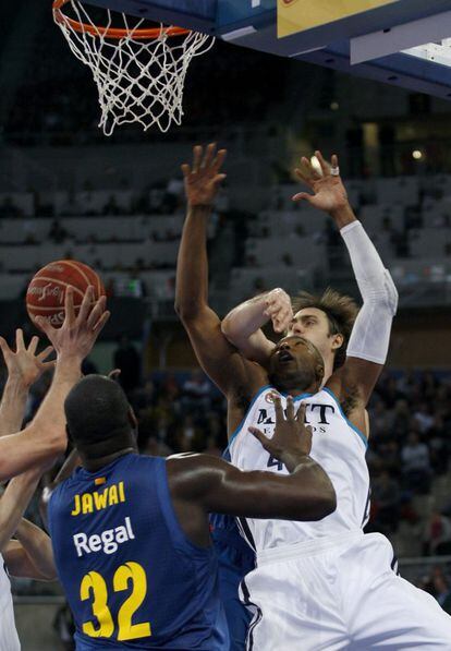 Lorbek, Jawai y Slaughter pugnan por un rebote.