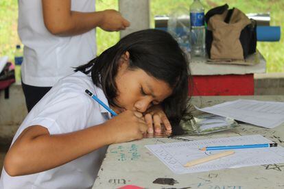 Alumna salvadoreña de primaria escribiendo en la escuela.