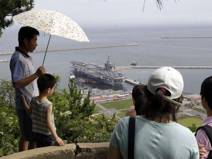 Un grupo de surcoreanos observa el portaaviones estadounidense <i>George Washington</i> en el puerto de Busan, al sur de Seúl.