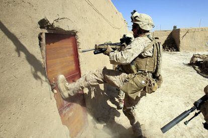 Un <i>marine</i> irrumpe en una casa durante una operación de búsqueda de armas en la ciudad afgana de Marjah.