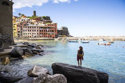 Una turista contempla el puerto de Vernazza, en una pausa de una ruta de 'trekking' por Cinque Terre.