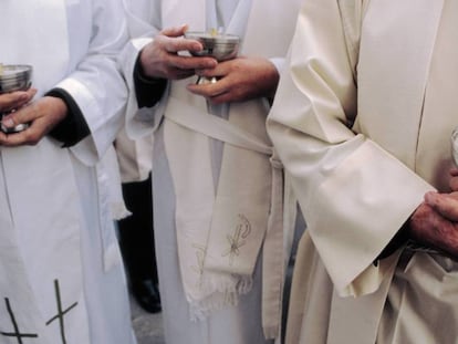 Sacerdotes con cálices durante una misa. 