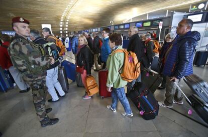 Diversos passatgers i un soldat francès a l'aeroport Charles de Gaulle, on roman el menor.