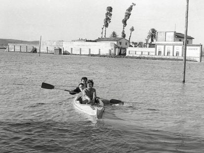 Tres personas navegan en piragua por la sevilla inundada de 1961.
