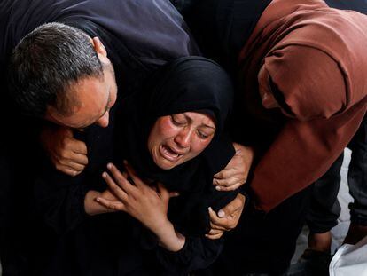 Una mujer llora junto a los cuerpos sin vida de unos palestinos asesinados por un bombardeo israelí en Rafah este martes.