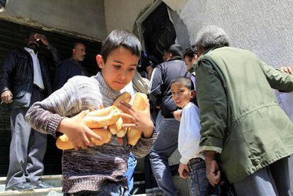 Un niño abandona una panadería tras comprar varias barras, ayer en Trípoli.