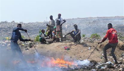 Los niveles de contaminación en Agbogbloshie superan con creces los tolerados por la Organización Mundial de la Salud (OMS). En la imagen, las montañas de desechos y un grupo de trabajadores.