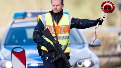 Un policia alemany ordena a un vehicle que s'aturi, a la frontera entre Bèlgica i Holanda.