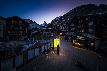 Una persona consulta un mapa retroiluminado en las calles vacías del municipio turístico de Zermatt, en los Alpes. El Gobierno suizo declaró el pasado 15 de marzo el estado de emergencia para evitar la expansión del coronavirus.
