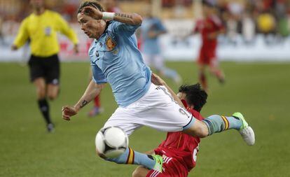 Un jugador chino derriba a Fernando Torres.
