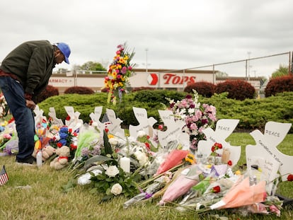 Un hombre llora en un monumento en la escena de un tiroteo de fin de semana en un supermercado Tops en Búfalo.