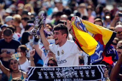 Aficionados del Real Madrid esperan la llegada del equipo blanco en la plaza de Cibeles, Madrid.