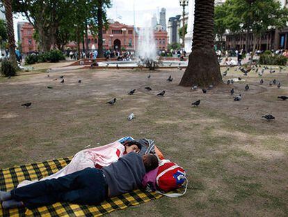 Una pareja duerme en la Plaza de Mayo, a las afueras de la Casa Rosada, en Buenos Aires.