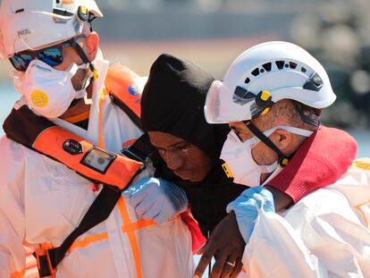 Dos trabajadores de Salvamento Marítimo ayudaban el día 2 de mayo a uno de los 60 inmigrantes localizados en un cayuco a 22 kilómetros de Arguineguín (Gran Canaria).