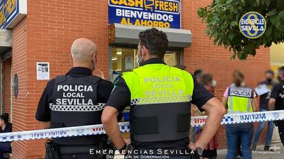 Varios agentes de la policía en las inmediaciones del supermercado de Sevilla en el que ha sido abatido un atracador este viernes por la tarde.