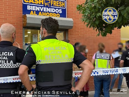 Varios agentes de la policía en las inmediaciones del supermercado de Sevilla en el que ha sido abatido un atracador este viernes por la tarde.