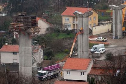 Pilares del viaducto que dará acceso al aeropuerto coruñés junto a varias casas del núcleo de A Hermida.