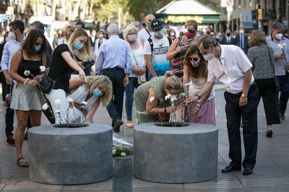 Familiars i amics de les víctimes dipositen flors durant l'acte.