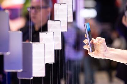 Un visitante toma fotografías de teléfonos móviles expuestos en el Mobile World Congress, esta mañana en Barcelona.