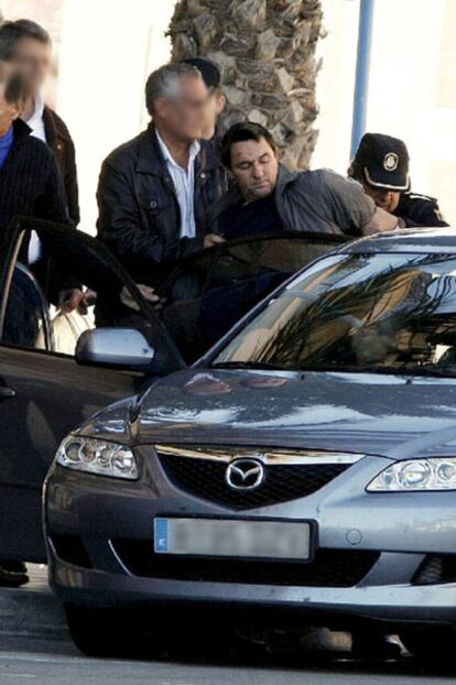 Agentes policiales introducen en el interior del vehículo al atracador.